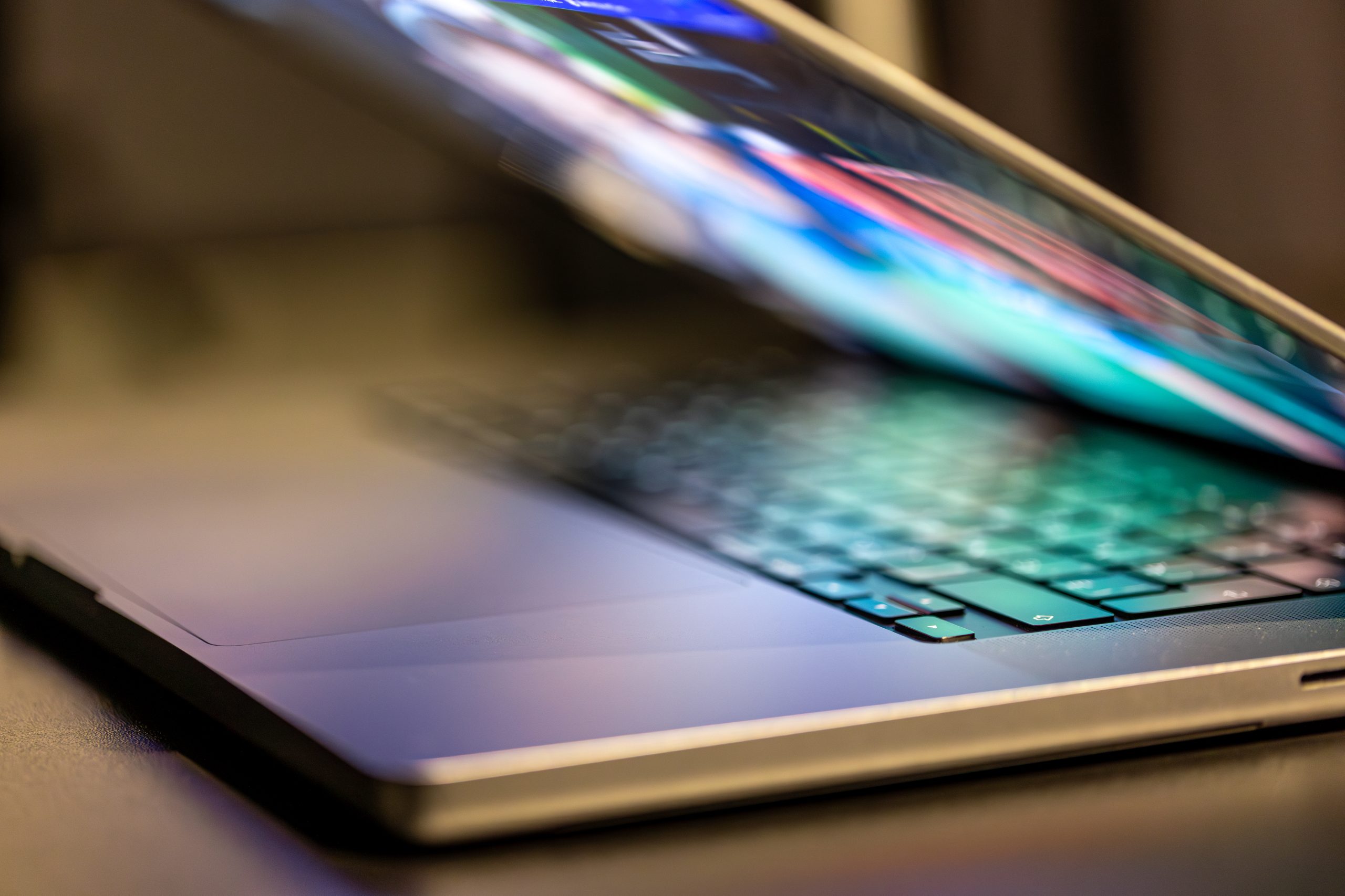 A laptop computer with a half-open screen on a dark background